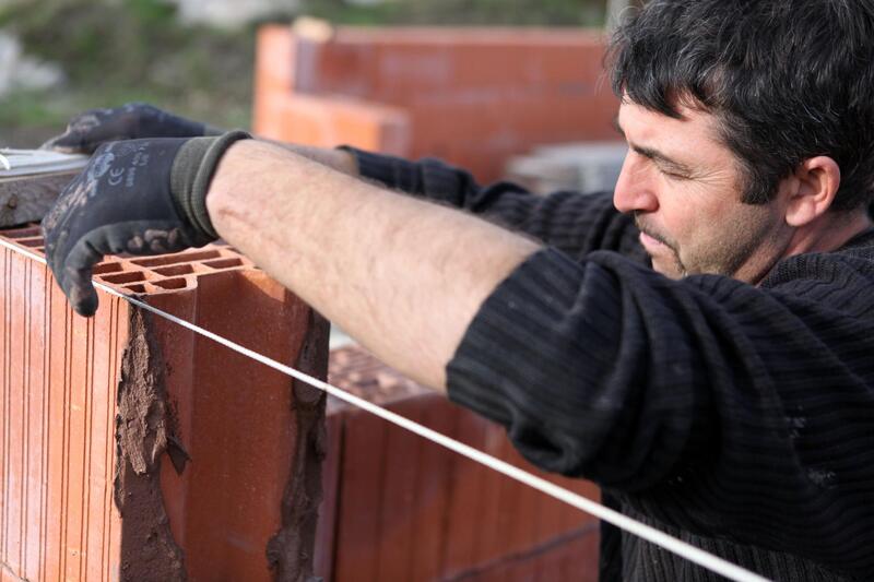man installing concrete bricks